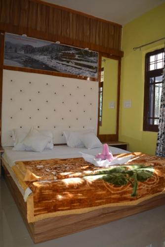 a bedroom with a large bed with a pink flower on it at Nice One Palace in Srinagar