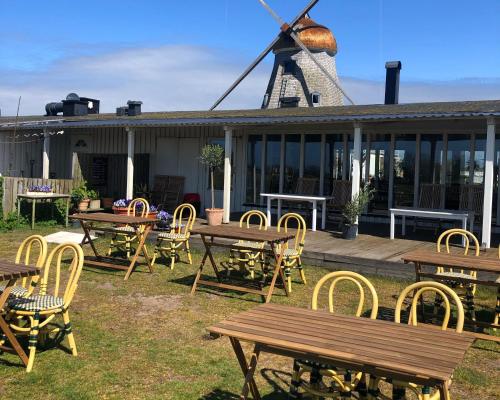 un grupo de mesas y sillas y un molino de viento en Kvarnen Pensionat och Restaurang en Falkenberg