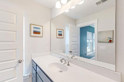 a white bathroom with a sink and a mirror at 4563 Summey Street in Charleston