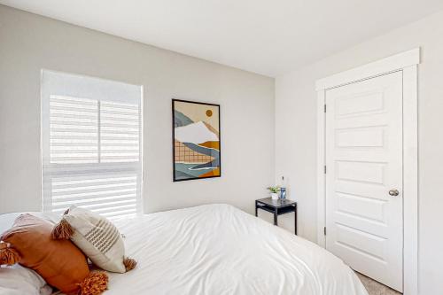 a white bedroom with a bed and a window at 4563 Summey Street in Charleston