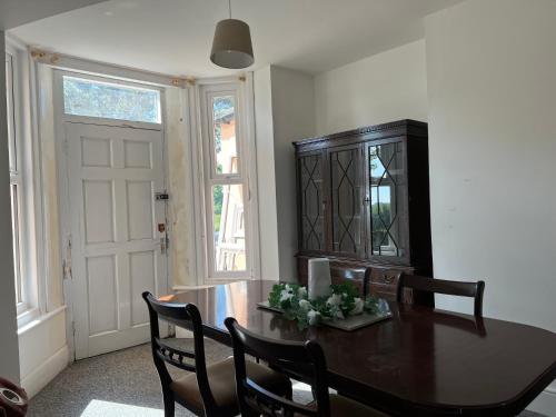 a dining room with a table and chairs and a window at Guestling House in Guestling