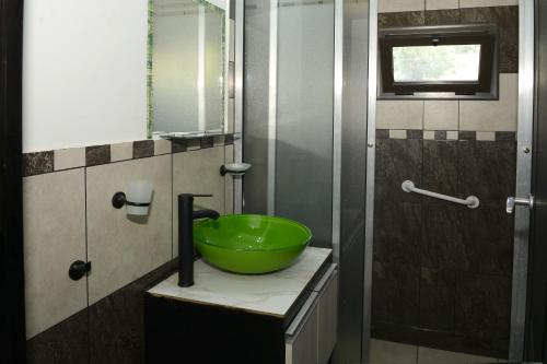 a bathroom with a green bowl on top of a sink at Complejo Los Cipreses in Villa Carlos Paz