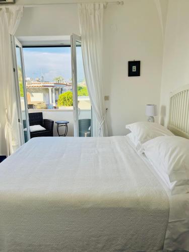 a bedroom with a large white bed and a balcony at B&B L'Agapanto in Capri