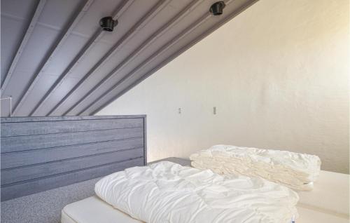 an unmade bed in a room with a ceiling at Feriehotal Tranum Klit in Brovst