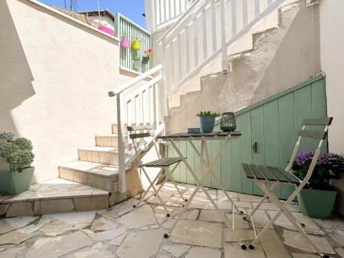 - une table et deux chaises sur une terrasse avec des escaliers dans l'établissement Old Town Premium Apartments, à Mostar