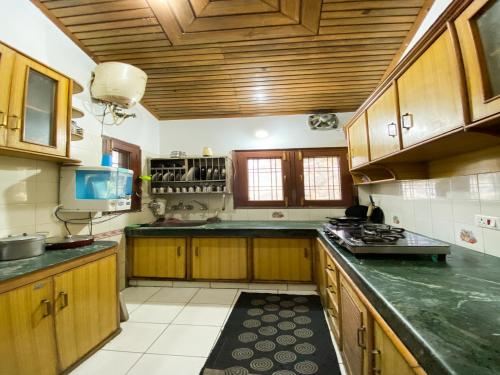 a kitchen with wooden cabinets and a counter top at Woods Luxury Homestay in Nainital