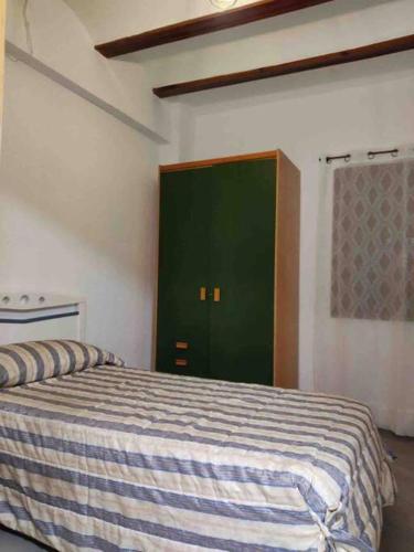 a bedroom with a bed with a green door at Casa Coletor in Chulilla