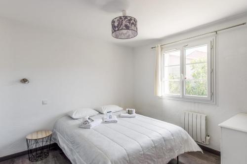 une chambre blanche avec un lit avec une fenêtre dans l'établissement Maison Mascarons - Welkeys, à Morières-lès-Avignon