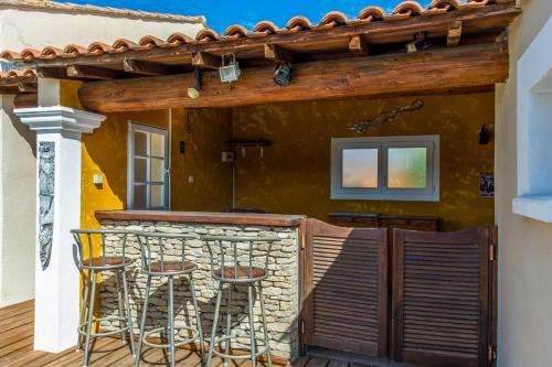 d'une terrasse avec 2 chaises et un mur en pierre. dans l'établissement Maison Mascarons - Welkeys, à Morières-lès-Avignon