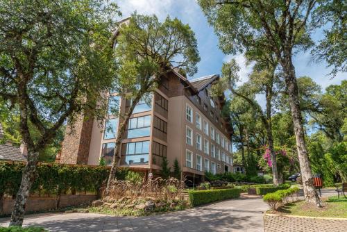 budynek z drzewami przed nim w obiekcie Hotel Monte Felice Bosque w mieście Gramado