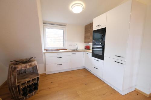 a kitchen with white cabinets and a window at Wohlfühloase am Trausdorfberg mit Sauna, Whirlpool und Panorama in Sankt Marein bei Graz