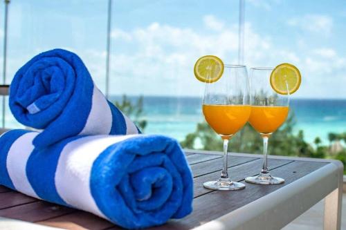 two glasses of orange juice and a towel on a table at 1 Rec. | A pasos de la playa | Roof c/Vista al mar in Playa del Carmen
