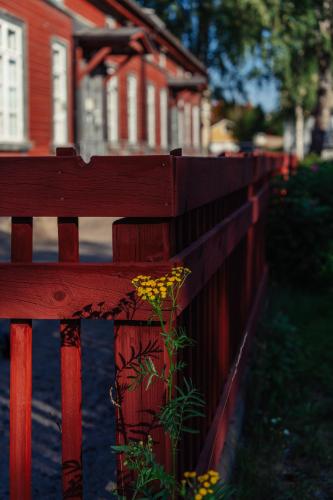 a red fence in front of a red house at Hostelli Marja in Mikkeli