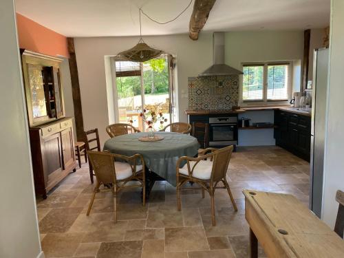 cocina y comedor con mesa y sillas en La chambre du tilleul en Capdrot