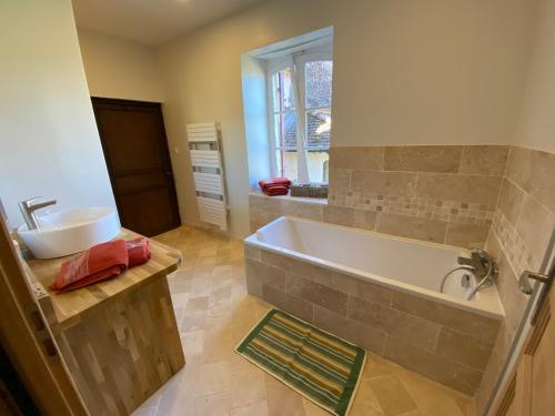 baño con bañera grande y lavamanos en La chambre du tilleul en Capdrot