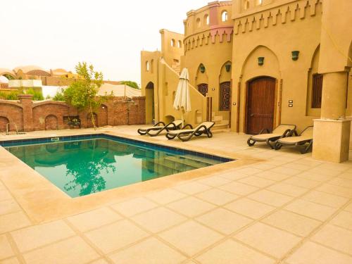 a swimming pool in the middle of a courtyard at Gold's Villa in Luxor