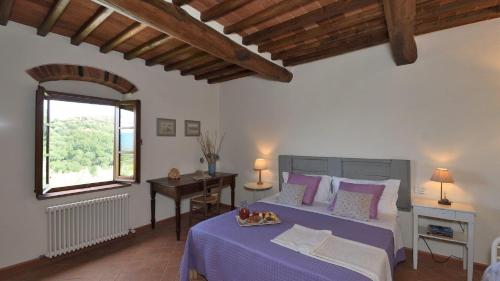 une chambre avec un lit, un bureau et une fenêtre dans l'établissement Poggio a Mandria, à Cavriglia