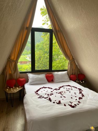 a bed with a heart on it in front of a window at Landhaus Borjomi in Borjomi