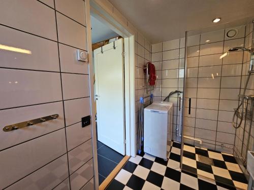 a bathroom with a black and white checkered floor at Borrebjär in Varberg