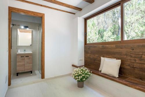 a bathroom with a bench with a window and a sink at Villa Jazmin in Sant Llorenç de Balafia