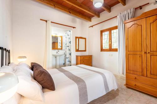 a bedroom with a large white bed and a sink at Villa Jazmin in Sant Llorenç de Balafia