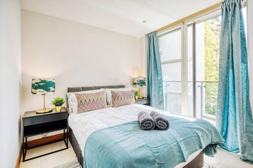 um quarto com uma cama e uma grande janela em Marylebone Station 2bed flat em Londres