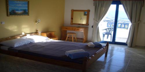 een slaapkamer met een bed, een bureau en een raam bij Horizon View Studios in Amoopi