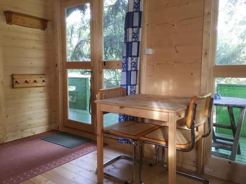drewniany stół i krzesła w pokoju z oknami w obiekcie U M&M w Łagowie