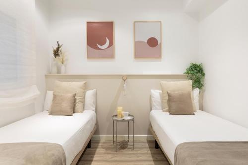バルセロナにあるKeyFamily Chic Studioの白い壁の客室内のベッド2台