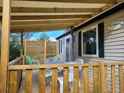 a deck with white chairs and a wooden pergola at Chez Coralie in La Roque-dʼAnthéron