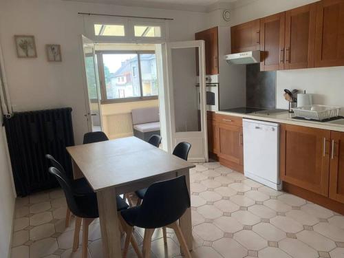 eine Küche mit einem Holztisch und Stühlen in der Unterkunft Spacieux Duplex centre Tours et bord du Cher Loire Valley in Tours