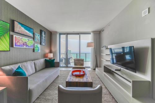 een woonkamer met een bank en een tv bij Iconic Ocean View - in this Stunning Condo in Hollywood