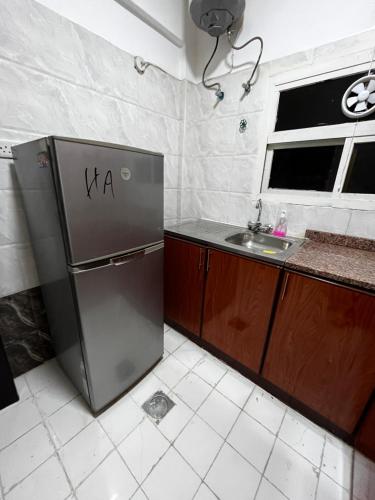a kitchen with a refrigerator and a sink at كورنيش عجمان in Ajman 