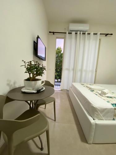 a bedroom with a bed and a table and a tv at Villa Arli&Eris in Vlorë