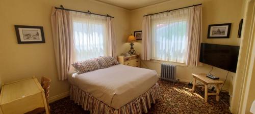 a bedroom with a bed and a flat screen tv at Historic Dow Hotel in Lone Pine