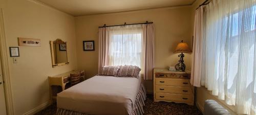 a bedroom with a bed and a window and a dresser at Historic Dow Hotel in Lone Pine