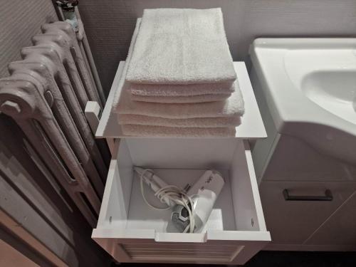 un tiroir blanc avec des serviettes et un lavabo dans une salle de bain dans l'établissement Superbe appartement 2 pièces - Aix-les-Bains Riviera des Alpes - Parking gratuit, à Aix-les-Bains