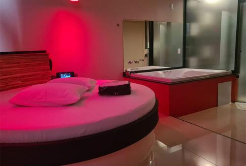 a pink bedroom with a bed and a bath tub at Prime Motel Americana in Americana