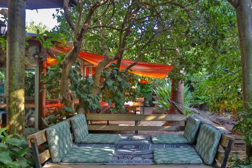 a wooden bench with two chairs under a tree at Çıralı Orange Motel in Cıralı