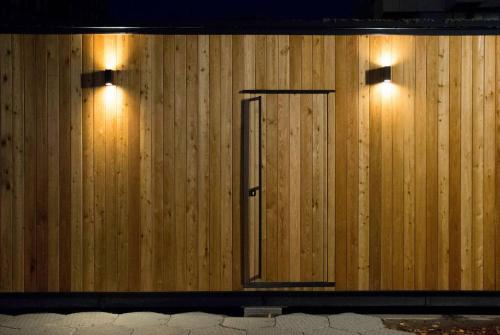 a wooden wall with two lights and a mirror at tiny house in Rotterdam