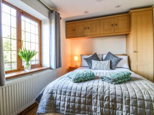 a bedroom with a bed with two pillows on it at Adelaide Cottage in Ashbourne