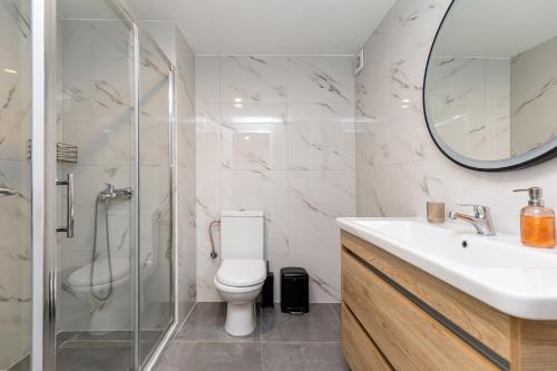 La salle de bains est pourvue de toilettes, d'un lavabo et d'un miroir. dans l'établissement Valentina's apartment, à Pouládes