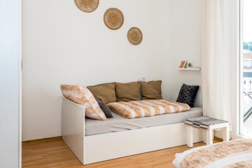 a white couch sitting in a room with a window at Apartment and Rooms Dalmatiko in Vodice
