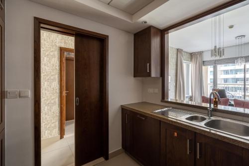 uma cozinha com um lavatório e um espelho grande em BellaVista 2 BR 29 Boulevard Downtown Burj Khalifa em Dubai