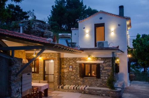 a house with a table in front of it at night at Villa Pounta Family in Glóssa