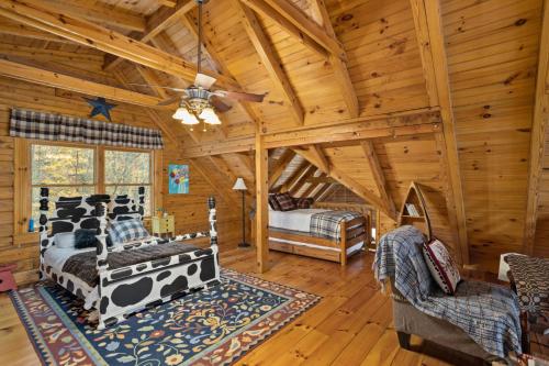 Cette cabane en rondins comprend 2 lits et un ventilateur de plafond. dans l'établissement Enlightened Elk Escape, à Banner Elk