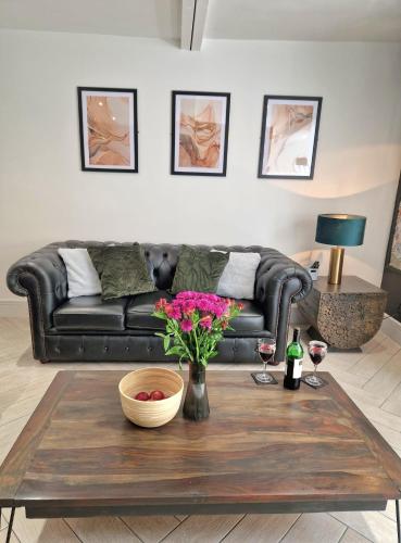 a living room with a couch and a table with flowers at Wesley Chapel- Cyanacottages in Whitby