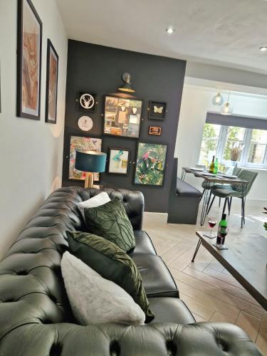 a living room with a leather couch and a table at Wesley Chapel- Cyanacottages in Whitby