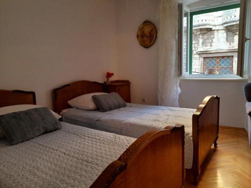 um quarto com 2 camas e uma janela em Two bells em Sibenik