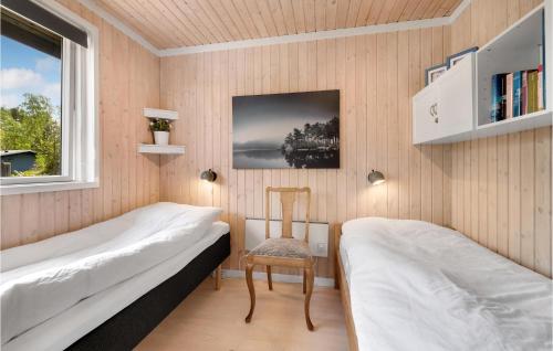 Vester SømarkenにあるNice Home In Aakirkeby With 3 Bedrooms And Wifiのベッドルーム1室(ベッド2台、椅子、窓付)